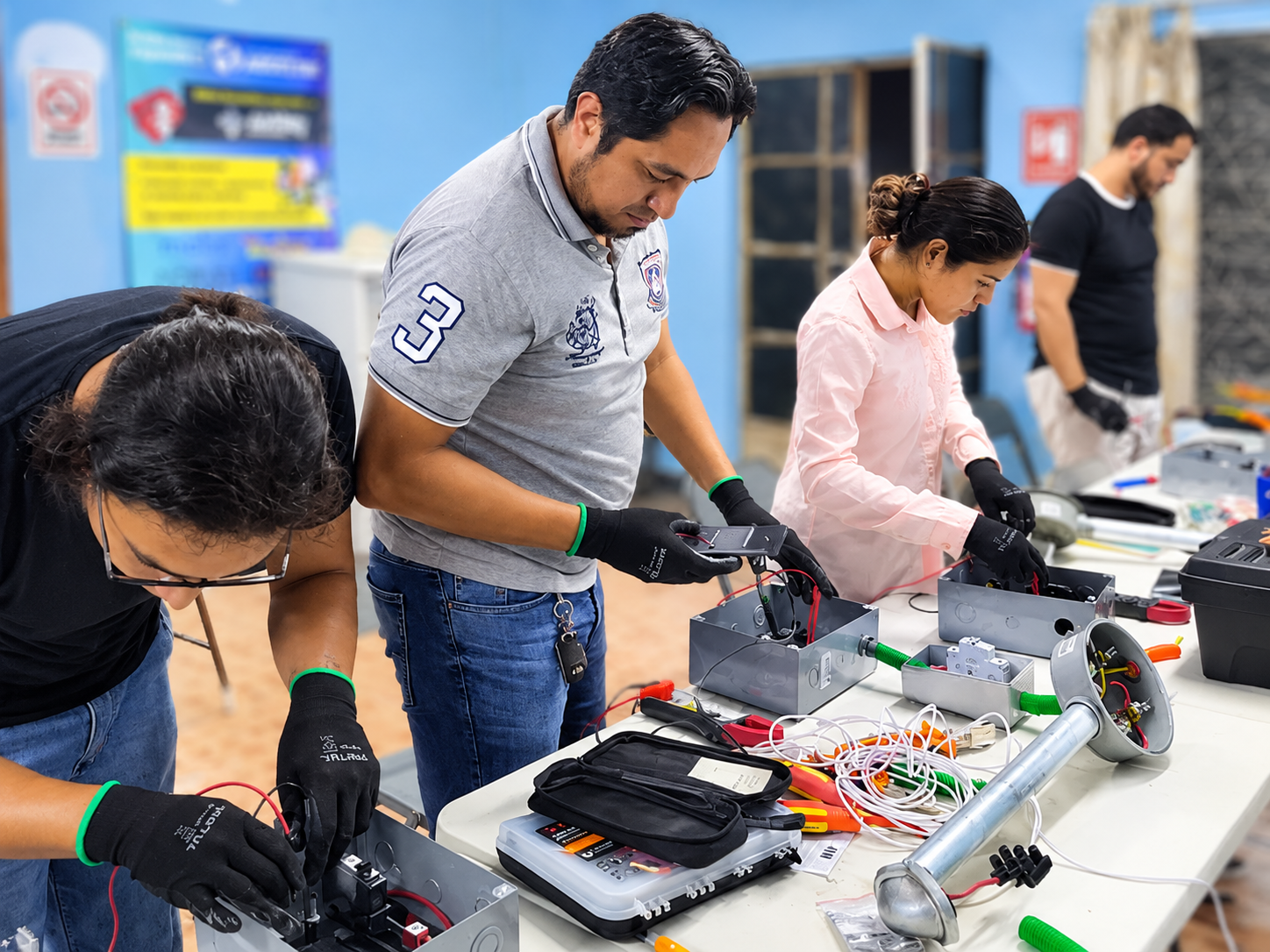 Alumnos cableando en equipo en el taller