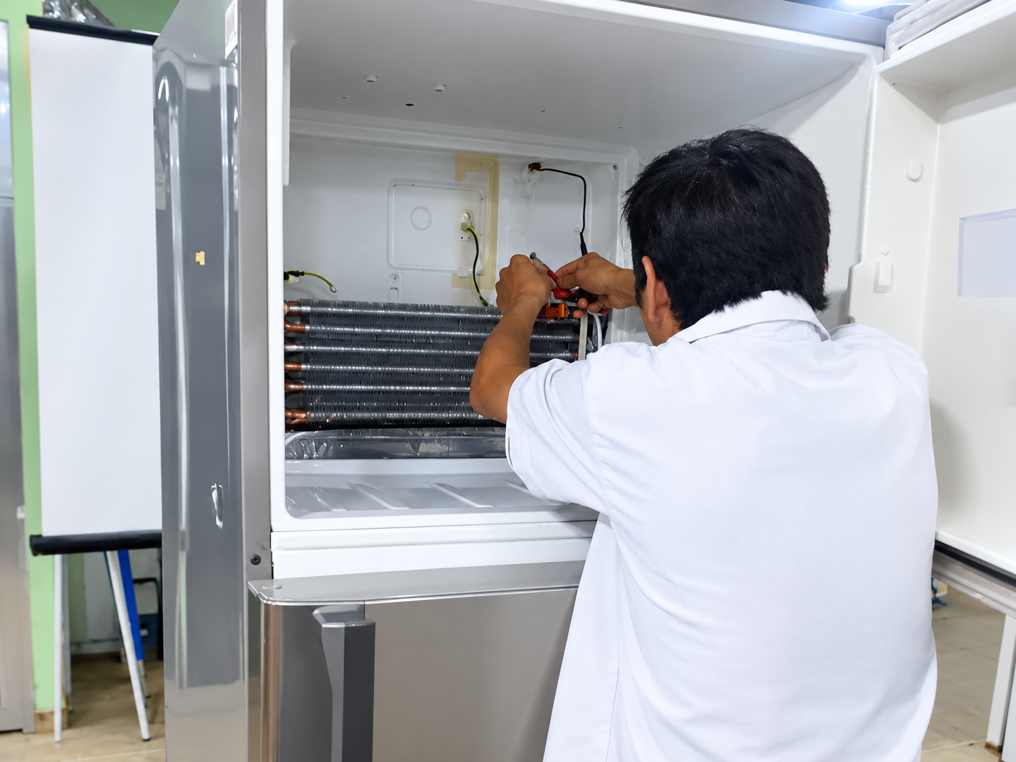 Alumno reparando un equipo de refrigeración